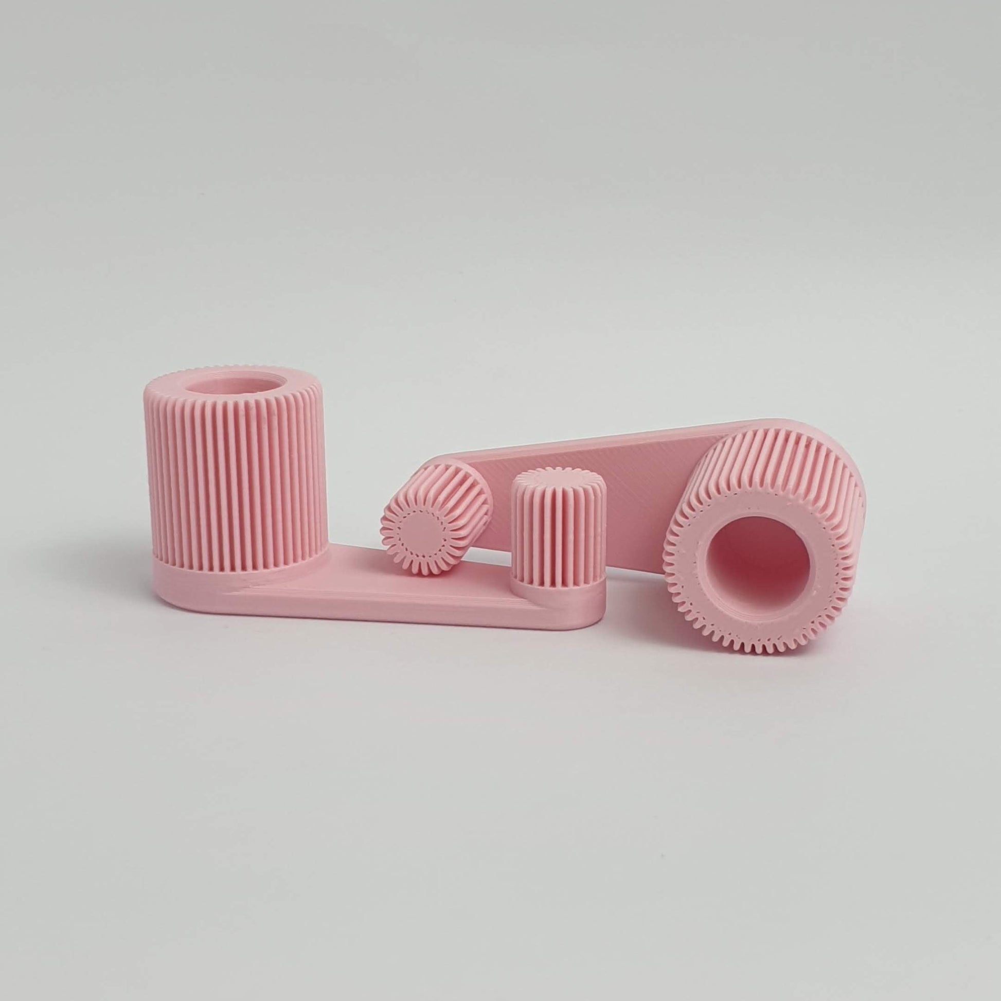3d printed pink mini portable laptop stand on a light gray background by Mina 3D Prints